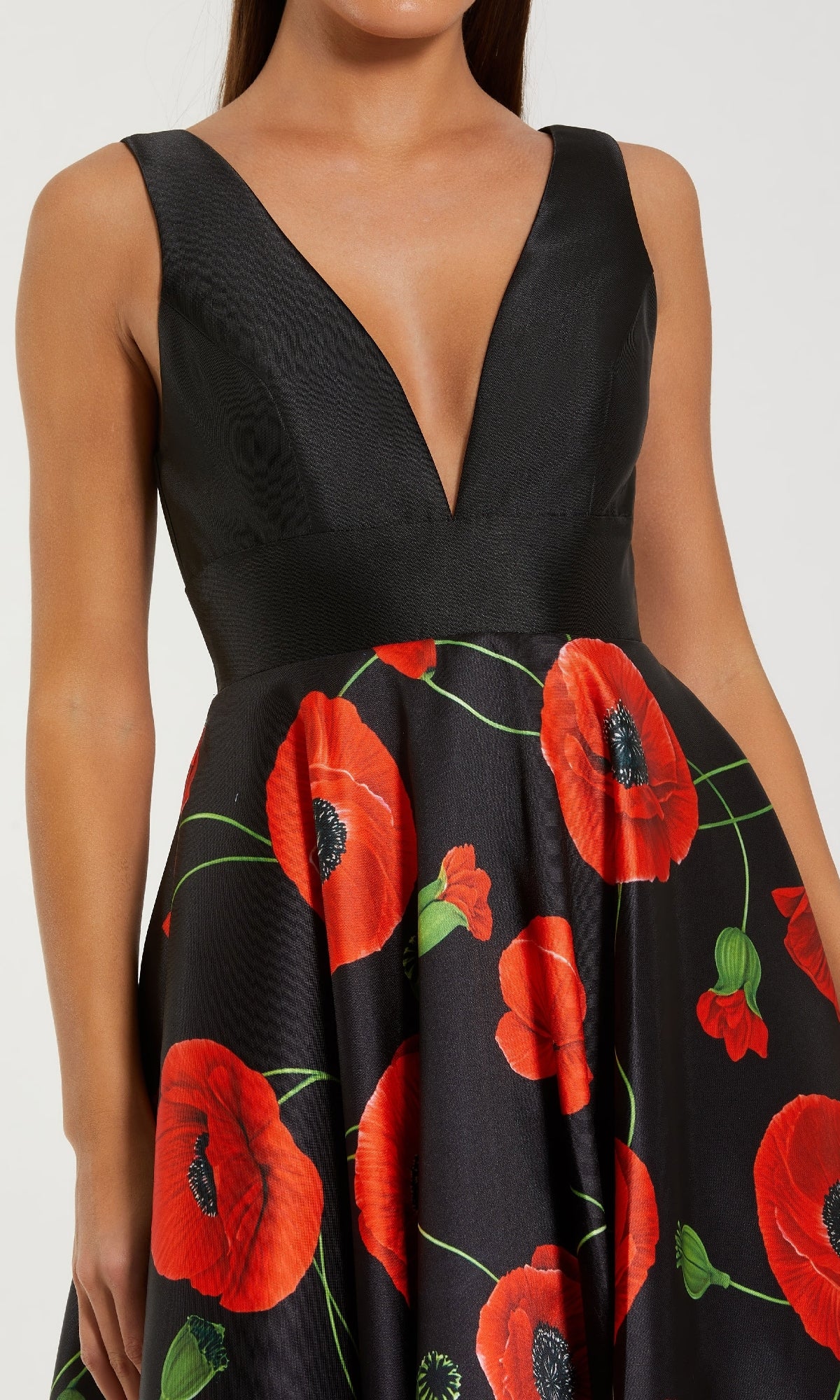 A woman wearing the Mac Duggal 56181 Long Black Poppy Formal Dress, a sleeveless gown with a deep V-neckline and a skirt adorned with vibrant red poppy flower print.